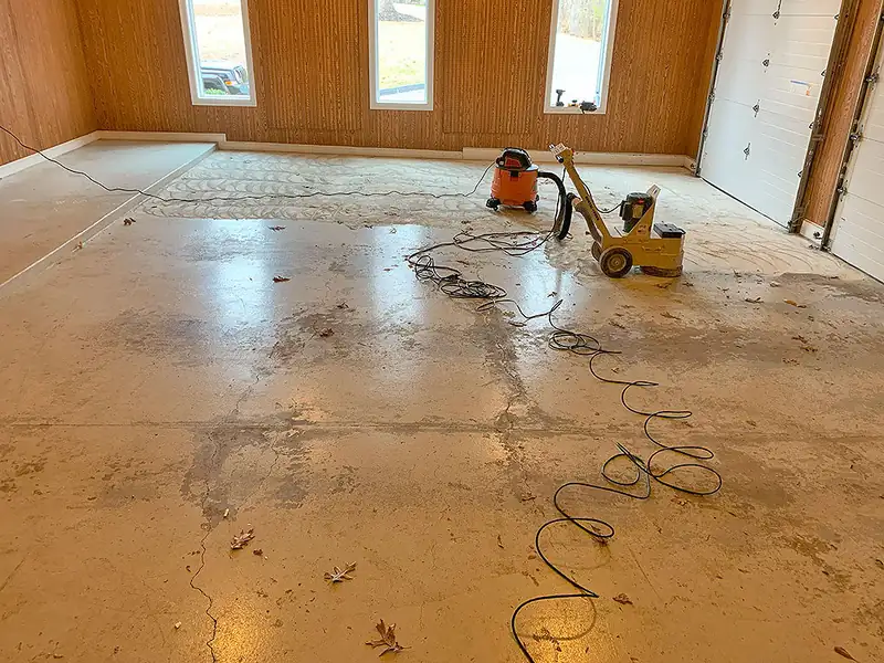 Worn bare concrete garage floor before coating